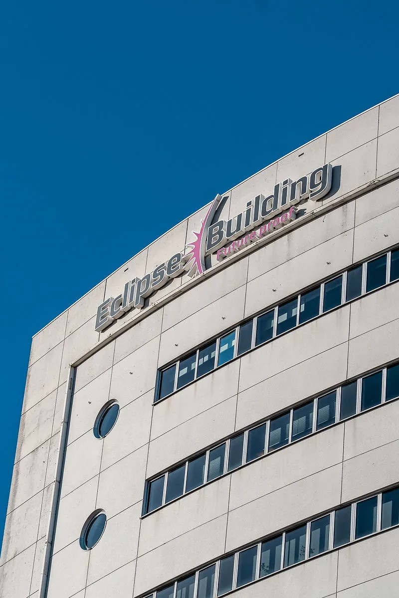 Voorgevel van het Eclipse Building aan het Rivium Quadrant met duidelijk zichtbaar logo en blauwe lucht op de achtergrond.